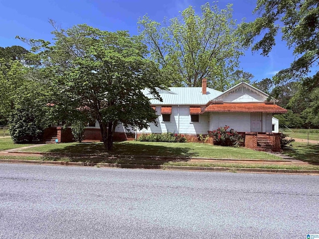 315 W Parkway Ave, Talladega, AL 35160 - view of front of property with a chimney, a front yard, and metal roof