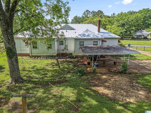 315 W Parkway Ave, Talladega, AL 35160 - rear view of house with a chimney, metal roof, and a lawn