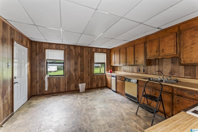 315 W Parkway Ave, Talladega, AL 35160 - kitchen featuring dishwasher, a sink, wooden walls, light countertops, and brown cabinets