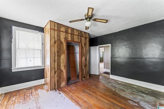 315 W Parkway Ave, Talladega, AL 35160 - unfurnished bedroom with wood-type flooring, baseboards, a closet, and multiple windows