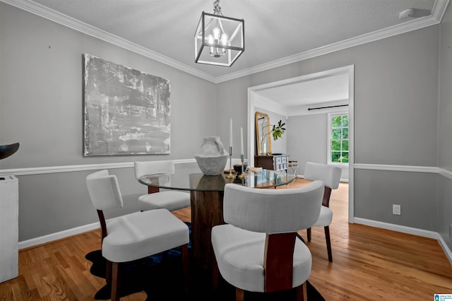 2208 Garland Dr, Vestavia Hills, AL 35216 - dining area featuring a chandelier, wood finished floors, baseboards, and crown molding