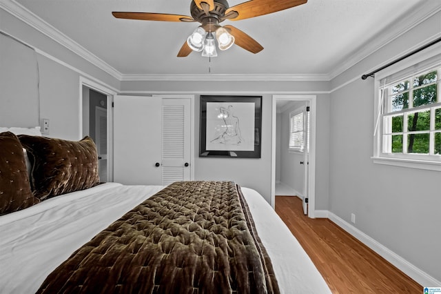 2208 Garland Dr, Vestavia Hills, AL 35216 - bedroom featuring wood finished floors, crown molding, baseboards, a ceiling fan, and a closet