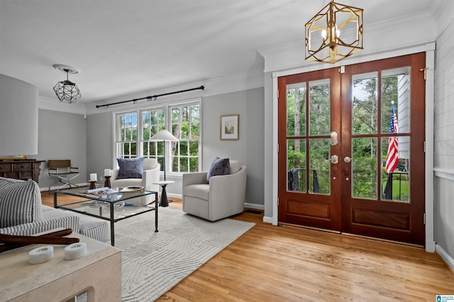 2208 Garland Dr, Vestavia Hills, AL 35216 - foyer with ornamental molding, french doors, a chandelier, light wood-type flooring, and baseboards