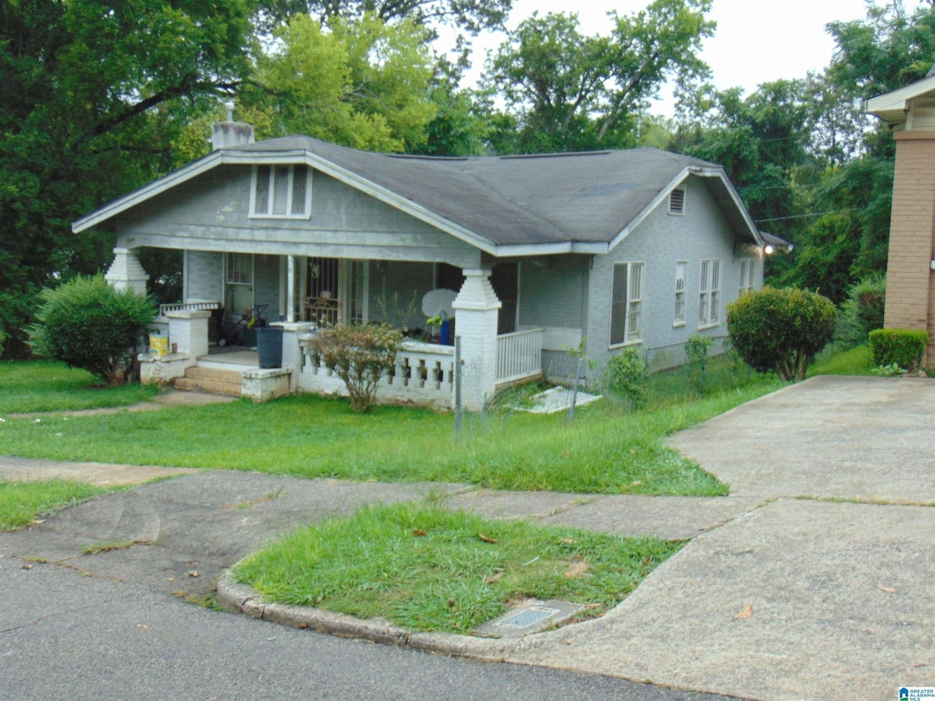 view of front facade featuring covered porch and a front yard