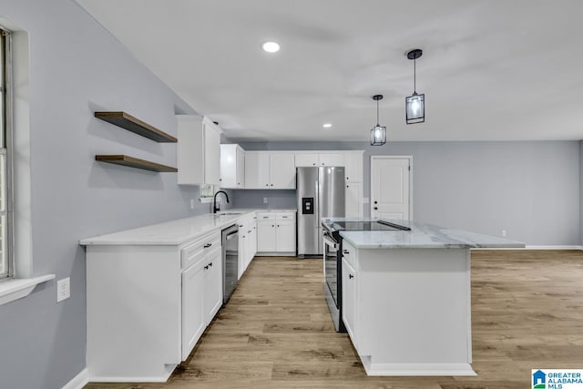5457 Snowville Brent Rd, Dora, AL 35062 - kitchen featuring stainless steel appliances, a sink, a center island, light stone counters, and light wood finished floors