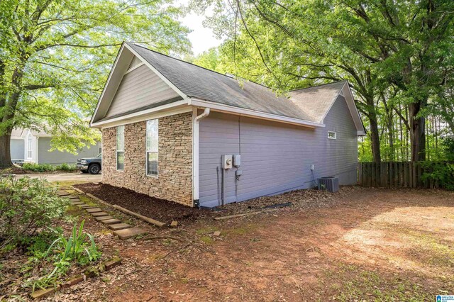 1834 Brandon Way, Bessemer, AL 35022 - view of home's exterior featuring stone siding, fence, cooling unit, and roof with shingles