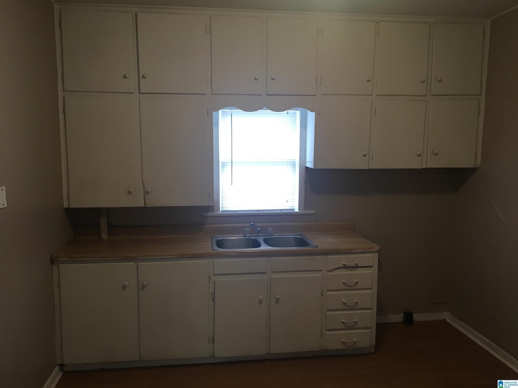 1308 Sloan Ave, Tarrant, AL 35217 - kitchen with a sink, white cabinetry, and baseboards