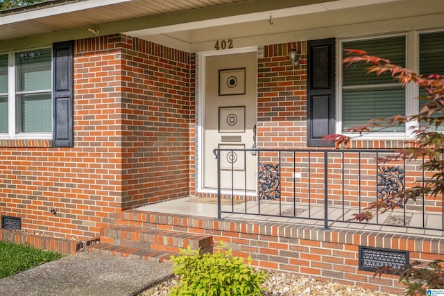 402 S 8th St, Gadsden, AL 35901 - view of exterior entry with crawl space, brick siding, and a porch