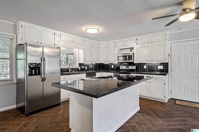 402 S 8th St, Gadsden, AL 35901 - kitchen with stainless steel appliances, white cabinets, a ceiling fan, a sink, and a textured ceiling