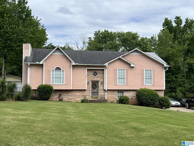 113 Fairlane Dr, Pleasant Grove, AL 35127 - split foyer home with a front lawn, a chimney, and brick siding