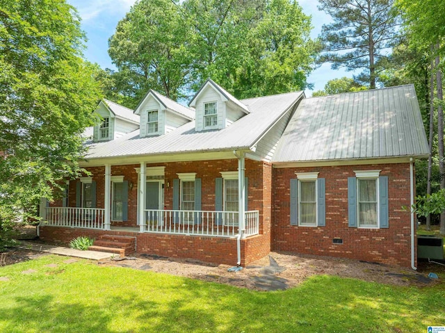 cape cod house with covered porch, a front yard, metal roof, and brick siding