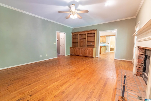unfurnished living room with a brick fireplace, a ceiling fan, light wood finished floors, baseboards, and ornamental molding