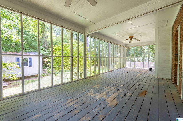 unfurnished sunroom with ceiling fan and healthy amount of natural light
