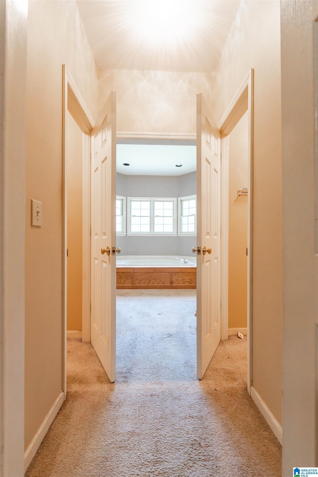 hall featuring light carpet and baseboards