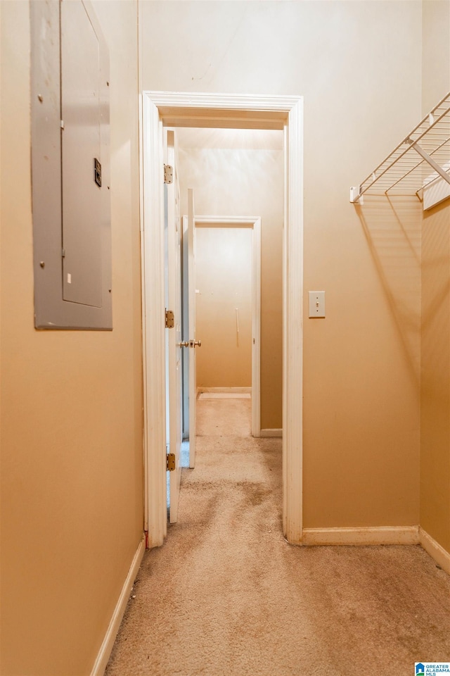 hallway featuring electric panel, carpet, and baseboards