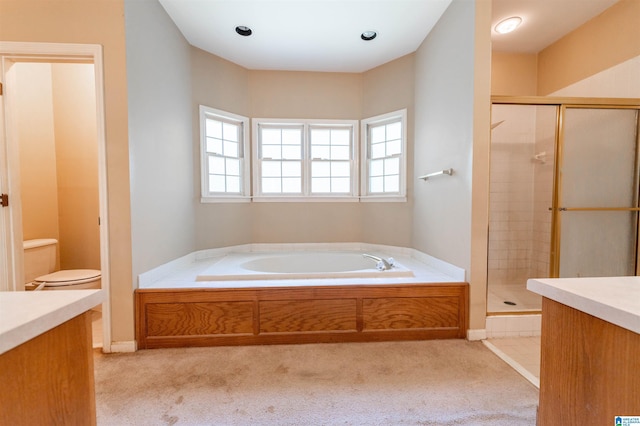 bathroom featuring a stall shower, a garden tub, and toilet