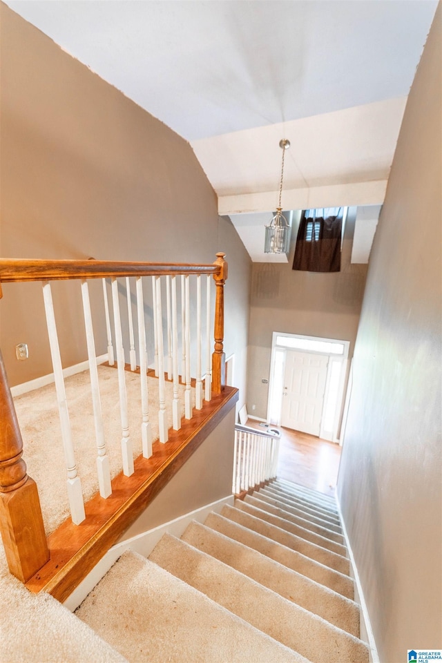 stairs featuring vaulted ceiling and carpet