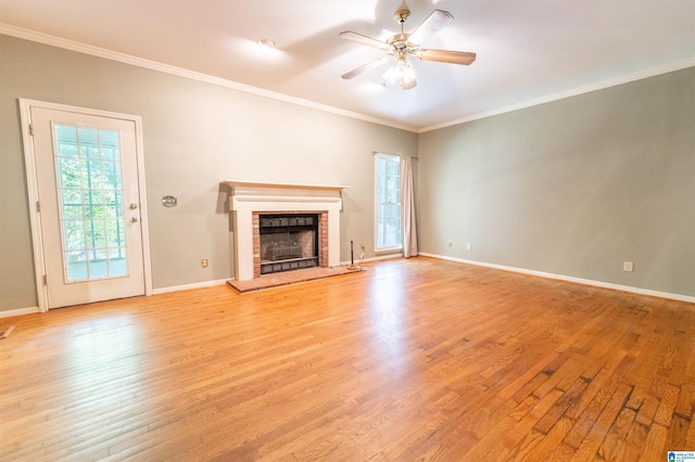 unfurnished living room featuring light wood-style floors, a fireplace, ornamental molding, a ceiling fan, and baseboards