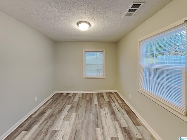 1424 33rd St, Ensley, Birmingham, AL 35218 - empty room with plenty of natural light, wood finished floors, a textured ceiling, and baseboards