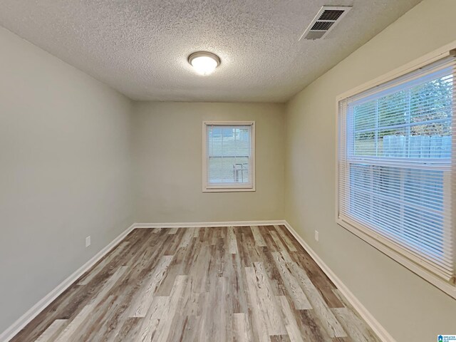 1424 33rd St, Ensley, Birmingham, AL 35218 - empty room with wood finished floors, a textured ceiling, and baseboards