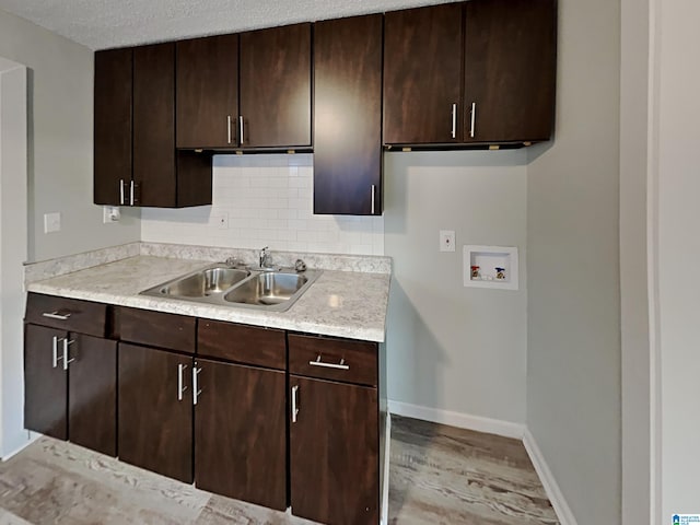 1424 33rd St, Ensley, Birmingham, AL 35218 - kitchen featuring a sink, light countertops, light wood-style floors, backsplash, and baseboards