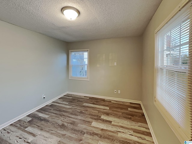 1424 33rd St, Ensley, Birmingham, AL 35218 - empty room featuring a textured ceiling, wood finished floors, and baseboards