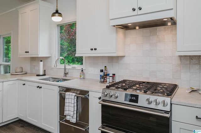 kitchen with stainless steel appliances, a sink, plenty of natural light, and white cabinetry