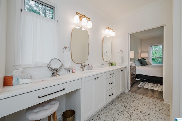bathroom with crown molding, vanity, and connected bathroom