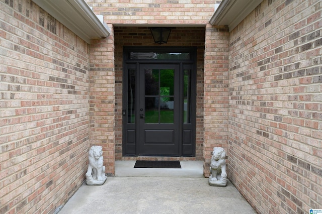 entrance to property featuring brick siding