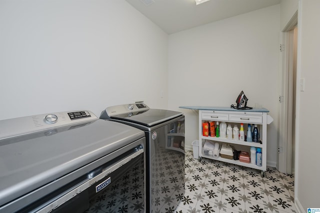 laundry area featuring washer and dryer, baseboards, and light floors