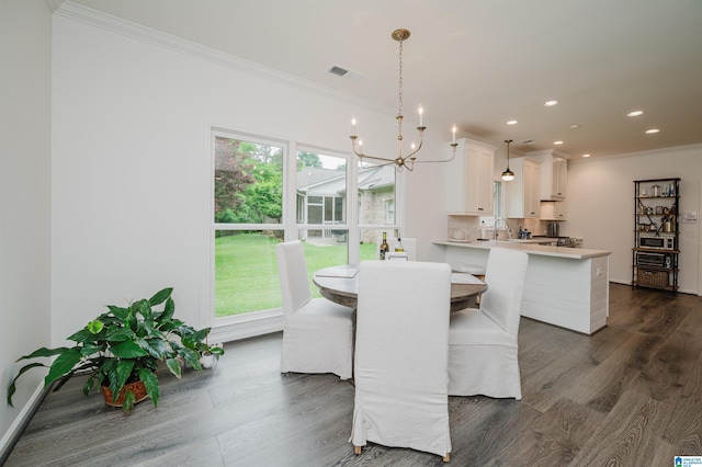 dining room with crown molding, dark wood finished floors, a chandelier, recessed lighting, and baseboards