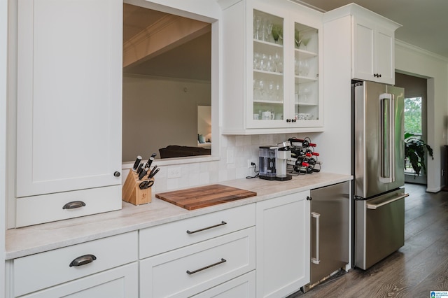 bar area featuring freestanding refrigerator, ornamental molding, decorative backsplash, dark wood-type flooring, and fridge