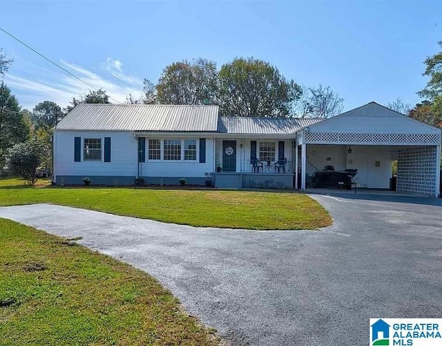 2020 Warrior Jasper Rd, Warrior, AL 35180 - single story home with asphalt driveway, a front yard, metal roof, a carport, and a porch