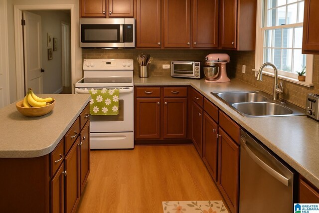 2020 Warrior Jasper Rd, Warrior, AL 35180 - kitchen featuring stainless steel appliances, a sink, light wood finished floors, decorative backsplash, and light countertops