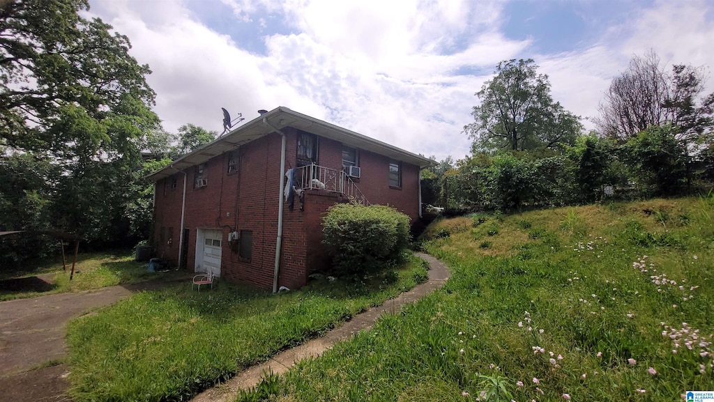 view of side of property featuring brick siding, a garage, and concrete driveway