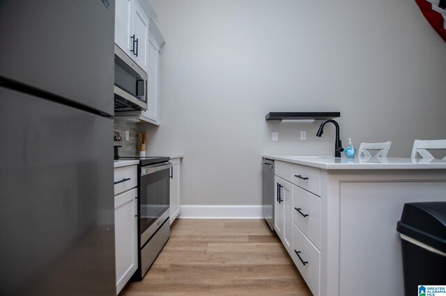 90 Landing Chase, Wedowee, AL 36278 - kitchen featuring stainless steel appliances, light wood finished floors, a sink, white cabinets, and light countertops