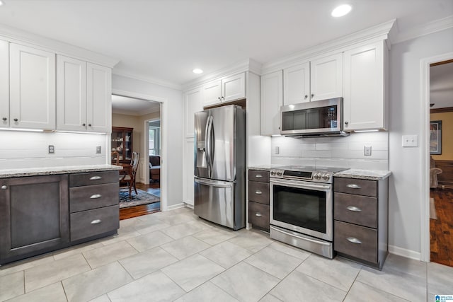 kitchen featuring stainless steel appliances, white cabinetry, crown molding, tasteful backsplash, and recessed lighting