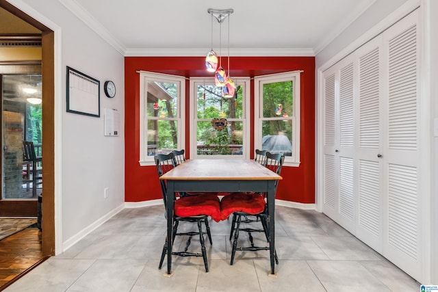 dining room with crown molding, plenty of natural light, baseboards, and light tile patterned floors