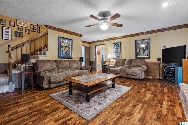 living room featuring wood finished floors, ceiling fan, stairs, a textured ceiling, and ornamental molding