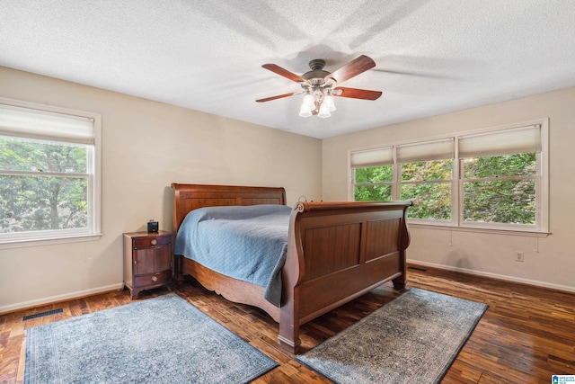 bedroom with baseboards, wood finished floors, a textured ceiling, and ceiling fan