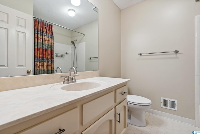 bathroom featuring toilet, tile patterned floors, vanity, a textured ceiling, and baseboards