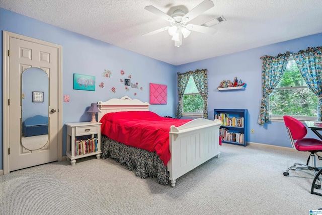 carpeted bedroom featuring a textured ceiling, a ceiling fan, and baseboards