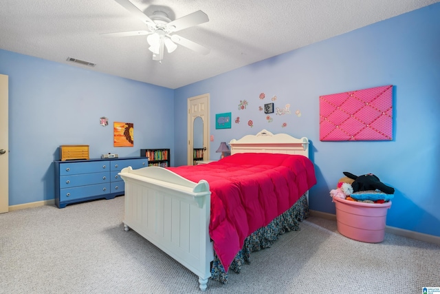 carpeted bedroom with a textured ceiling, ceiling fan, and baseboards