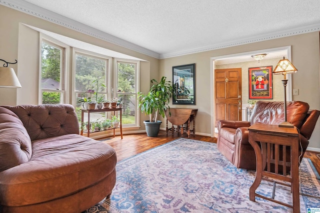 living room with a textured ceiling, wood finished floors, ornamental molding, and baseboards