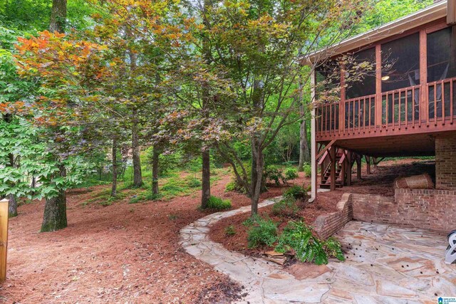 view of yard featuring stairway, a wooden deck, and a patio