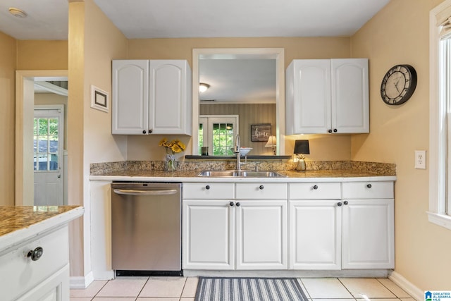117 Morris Blvd, Homewood, AL 35209 - kitchen featuring stainless steel dishwasher, a sink, light tile patterned flooring, white cabinets, and baseboards