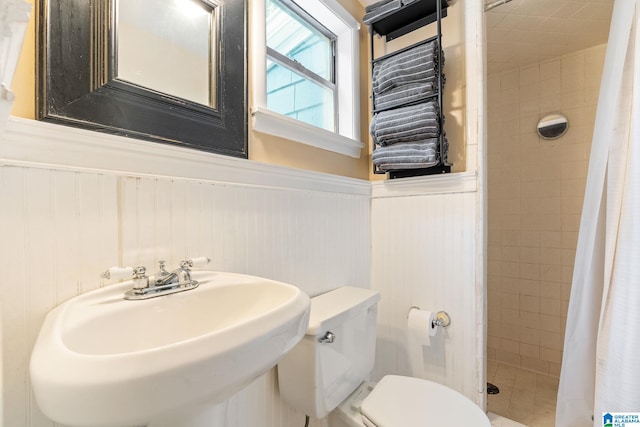 117 Morris Blvd, Homewood, AL 35209 - bathroom with a shower stall, toilet, a sink, wainscoting, and a decorative wall
