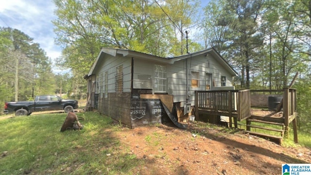 view of home's exterior featuring a deck and a lawn
