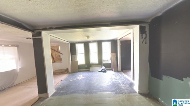 hall featuring a textured ceiling