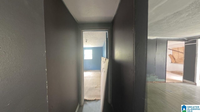 corridor featuring a textured ceiling and wood finished floors